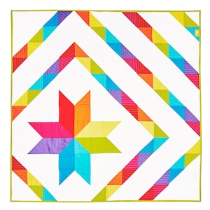 May include: A colorful quilt with a large star in the center. The star is made of six points, each a different color: red, orange, yellow, green, blue, and purple. The background of the quilt is white, and the border is a green, yellow, and orange pattern.