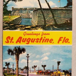 May include: Vintage postcard featuring a scenic view of St. Augustine, Fla. The top half shows a stone fort with a water-filled moat and an American flag. The bottom half depicts a street with horse-drawn carriages and palm trees under a blue sky. Text reads "Greetings from St. Augustine, Fla."