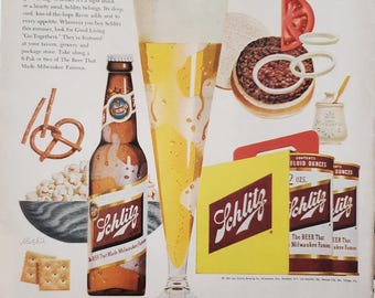 May include: A vintage advertisement for Schlitz beer featuring a glass of beer, a bottle of beer, and various food items, including pretzels, popcorn, crackers, and a hamburger. The text on the advertisement reads "Good Living Go-Togethers" and "Know the real joy of good living... move up to Schlitz!"