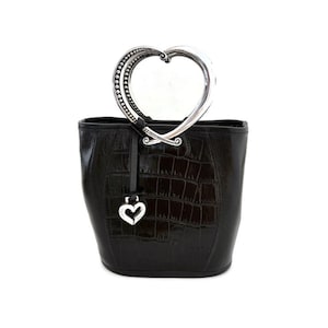 Pu&ograve; includere: Borsa a mano in pelle nera con manico a forma di cuore argentato e ciondolo a forma di cuore argentato.