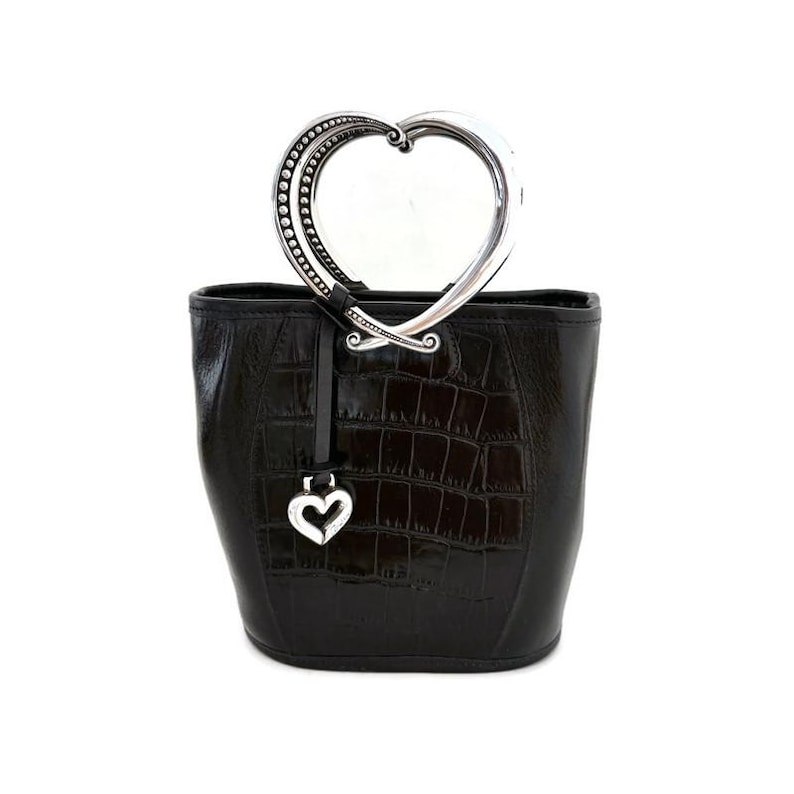 Pu&ograve; includere: Borsa a mano in pelle nera con manico a forma di cuore argentato e ciondolo a forma di cuore argentato.