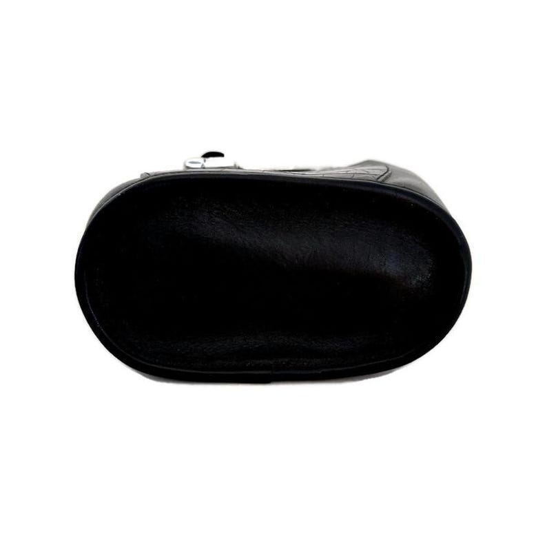 Pu&ograve; includere: Borsa a mano in pelle nera con chiusura a zip. La borsa &egrave; mostrata dal basso, rivelando la fodera in pelle liscia.