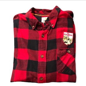 May include: Red and black checked flannel shirt with a patch on the pocket that says "Mt. Rushmore, SD" and features a depiction of the four presidents.