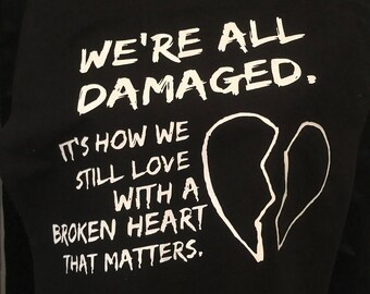 We're all damaged tote bag