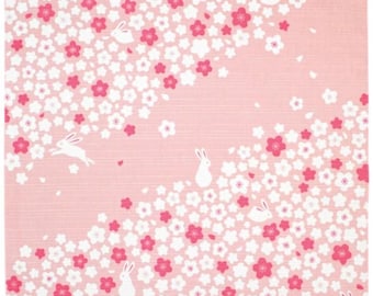 Puede incluir: Tela rosa con un patrón floral blanco y rosa y conejos blancos. La tela tiene una textura rayada sutil.