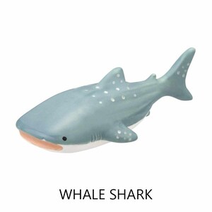 May include: A light blue whale shark figurine with white spots. The figurine has a light pink mouth and black eyes. The text "WHALE SHARK" is printed in black below the figurine.