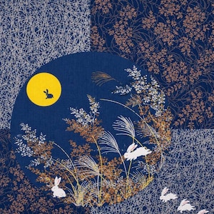 Pode incluir: Um design de tecido com fundo azul escuro, lua amarela e coelhos brancos. O design inclui plantas e flores estilizadas em branco, castanho e dourado. O fundo tem um padrão de patchwork com um design prateado semelhante a uma teia de aranha e motivos florais.