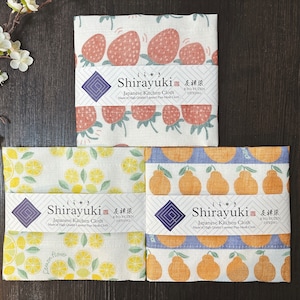 May include: Three Japanese kitchen cloths with different fruit designs. The top cloth features strawberries, the middle cloth features lemons, and the bottom cloth features oranges. Each cloth has a label that reads "Shirayuki Japanese Kitchen Cloth" and "KYO-YUUZEN DYEING".