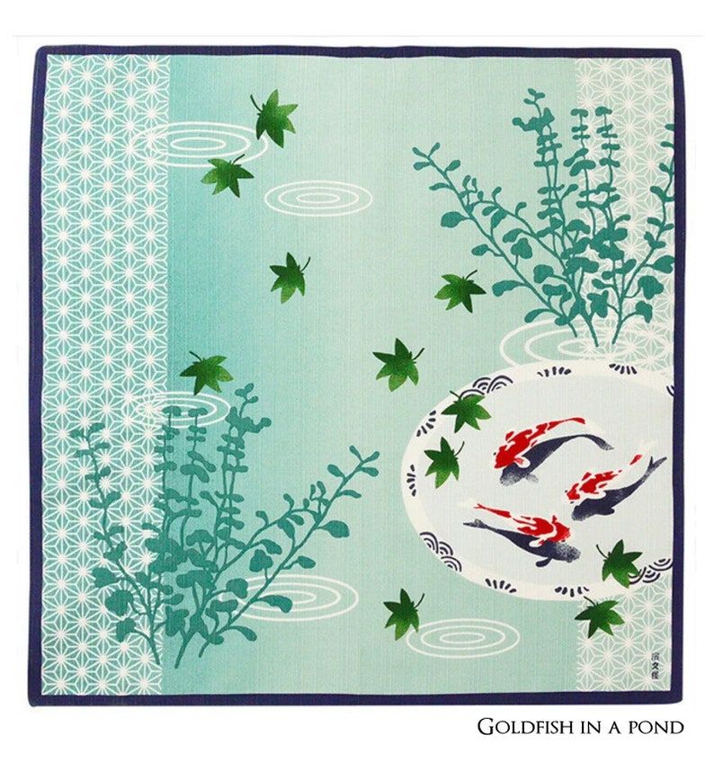 Op de afbeelding: Een blauw en groen vierkant van stof met een ontwerp van goudvissen die zwemmen in een vijver met waterlelies en bladeren. De tekst "Goldfish in a Pond" is onderaan het vierkant gedrukt.