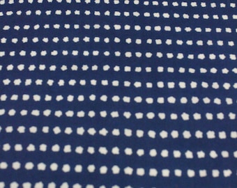 May include: A navy blue fabric with a white polka dot pattern. The dots are small and evenly spaced.