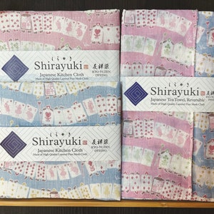 Peut inclure: Deux serviettes de thé japonaises réversibles avec un motif rose et bleu représentant des cartes à jouer et un motif de lapin. Les serviettes sont faites de tissu en maille fine de haute qualité et sont étiquetées "Shirayuki" avec le texte "Serviette de thé japonaise, réversible" et "Fabriqué en tissu en maille fine de haute qualité".