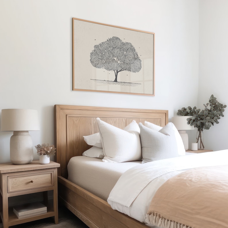 May include: A bedroom with a wooden bed frame, white bedding, and a beige throw blanket. There is a framed print of a tree above the bed, and a lamp on a bedside table next to the bed.