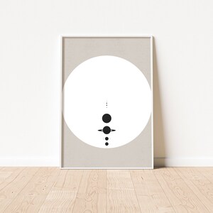 May include: A minimalist black and white print of a stylised solar system with planets and rings on a beige background.