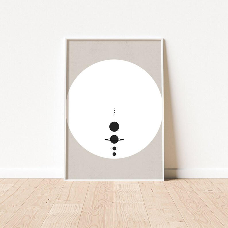 May include: A minimalist black and white print of a stylised solar system with planets and rings on a beige background.