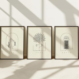 Puede incluir: Tres impresiones art&iacute;sticas enmarcadas con dibujos lineales minimalistas. Las impresiones presentan un par de manos, un &aacute;rbol y una puerta, cada uno sobre un fondo crema. Las palabras "ASK", "SEEK" y "KNOCK" est&aacute;n escritas debajo.