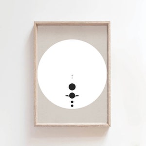 May include: A minimalist black and white print of a solar system with planets and rings in a circle on a beige background. The print is framed in a light wood frame.