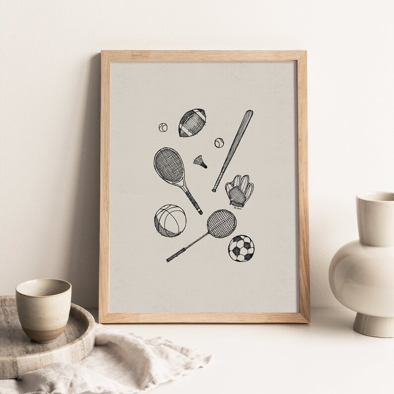 K&ouml;nnte beinhalten: Gerahmter Kunstdruck mit einer schwarz-wei&szlig;en Illustration verschiedener Sportger&auml;te. Das Bild zeigt einen Football, Baseballschl&auml;ger, Tennisschl&auml;ger, Basketball, Badmintonschl&auml;ger, Fu&szlig;ball und Baseballhandschuh. Das Kunstwerk ist in Schwarzwei&szlig; auf neutralem Hintergrund.