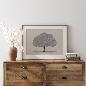 May include: A framed black and white line drawing of a tree with a simple background. The frame is brown wood and the drawing is on a beige background. The drawing is on a wooden dresser with two drawers.