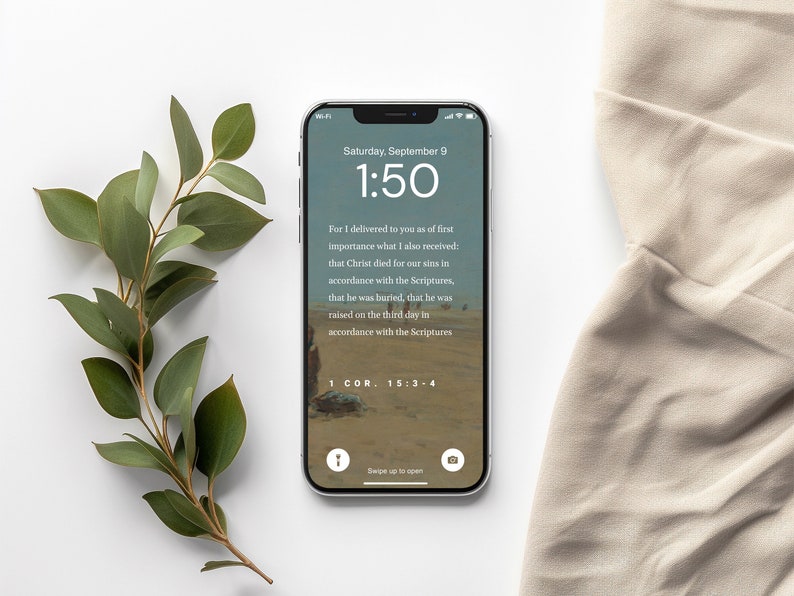 Pu&ograve; includere: Lo schermo di uno smartphone che mostra un versetto biblico di 1 Corinzi 15:3-4. Il versetto parla della morte, della sepoltura e della risurrezione di Ges&ugrave; Cristo. L'immagine di sfondo &egrave; un paesaggio desertico. L'ora sul telefono &egrave; le 1:50.