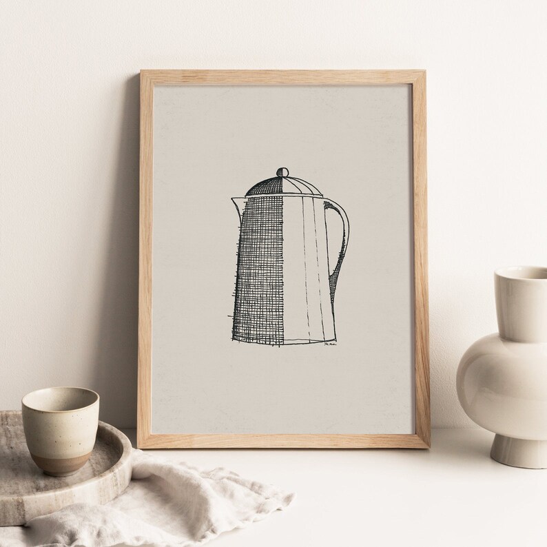 May include: A black and white line drawing of a coffee pot with a lid and a handle. The drawing is on a light beige background and is framed in a light wood frame.