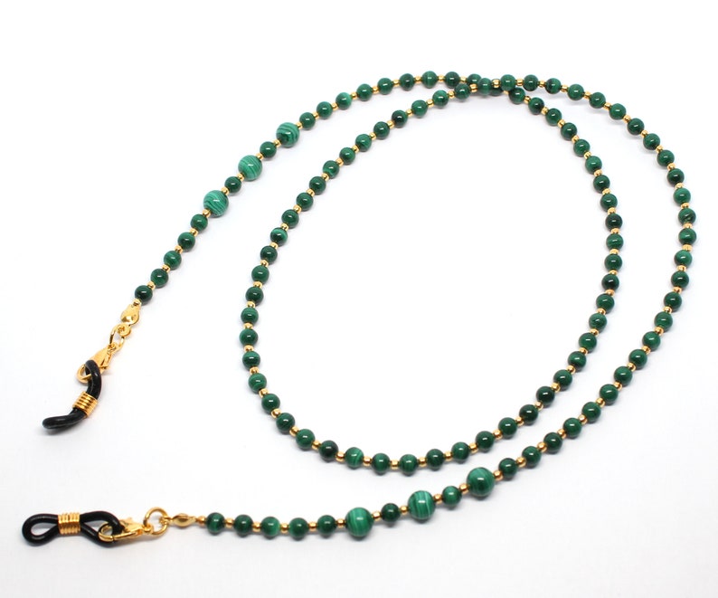 May include: A green malachite and gold chain eyeglass holder. The chain is made of small gold beads with green malachite beads interspersed throughout.