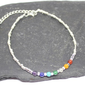 May include: Silver anklet with a rainbow of coloured beads, including purple, blue, green, yellow, orange, and red.
