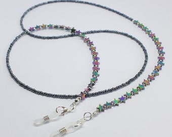 May include: A pair of iridescent star-shaped bead glasses chains with silver-toned metal clasps and clear plastic ear hooks.