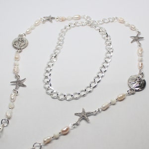 Puede incluir: Un collar de cadena de plata con cuentas de perlas blancas y rosadas, abalorios de estrella de mar y abalorios de concha de plata.
