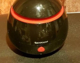 May include: Black essential oil diffuser with a red accent ring and a red button. The diffuser has the text "spareroom" on the front.