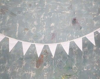 May include: A white bunting banner with triangular flags hangs against a textured blue background.