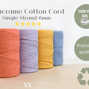 May include: Four spools of 6mm macrame cotton cord in coral, lavender, yellow, and blue. The cord is 1000 feet (305 meters) long and is described as premium quality. The image also includes a recycling symbol.
