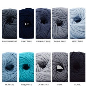 Puede incluir: Diez ovillos de lana en varios tonos de azul, gris y negro. La lana est&aacute; dispuesta en dos filas de cinco ovillos cada una.