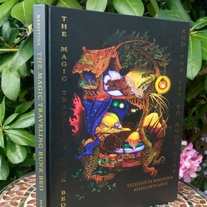 May include: A black hardcover book with gold lettering titled "The Magic Traveling Bunk Bed and the Key to Moon City" by Yelizaveta Bakhtina and Kiana Donahue. The cover features an illustration of a magical bed with a house on top, surrounded by a forest and a glowing lantern.