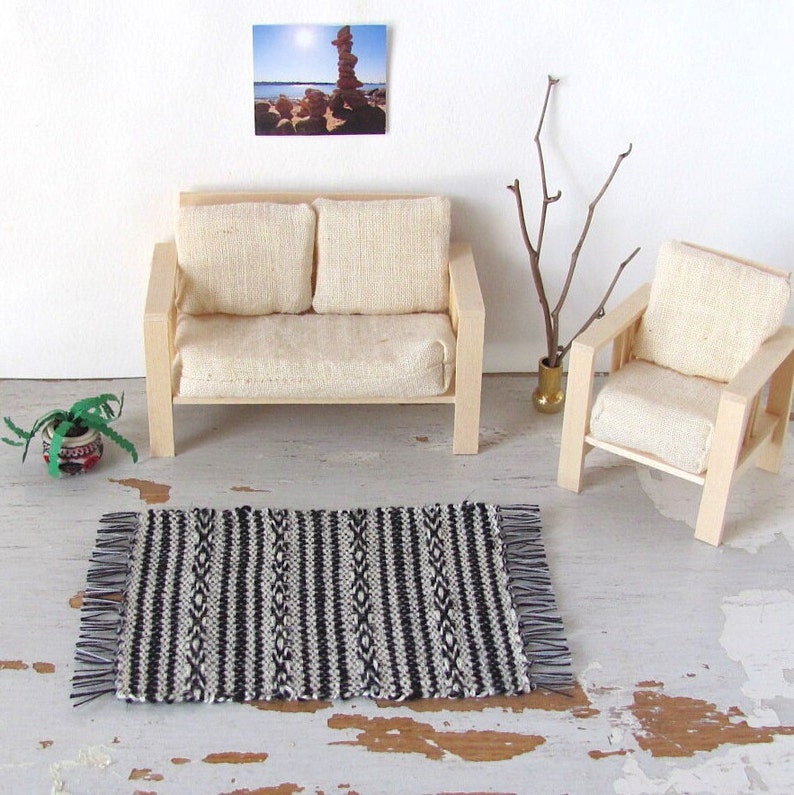 Handmade Inch to Foot Dollhouse Miniature Rug or Carpet,  1:12 Scale Artisan Hand Woven Black and Off-White Stripe and Diamond Pattern Scandinavian Modern, Rustic Farmhouse, Beach Cottage, or Southwest Desert Ranch Collector Dolls House Furniture Accessory Textile. Styled with a couch and chair, a floor vase with sticks, a potted cactus, and a rock photo on the wall.