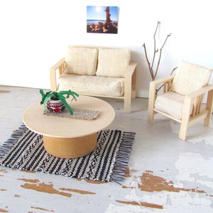 Handmade Inch to Foot Dollhouse Miniature Rug or Carpet,  1:12 Scale Artisan Hand Woven Black and Off-White Stripe and Diamond Pattern Scandinavian Modern, Rustic Farmhouse, Beach Cottage, or Southwest Desert Ranch Collector Dolls House Furniture Accessory Textile. Styled with a couch and chair, a floor vase with sticks, a potted cactus on a round coffee table, and a rock photo on the wall.
