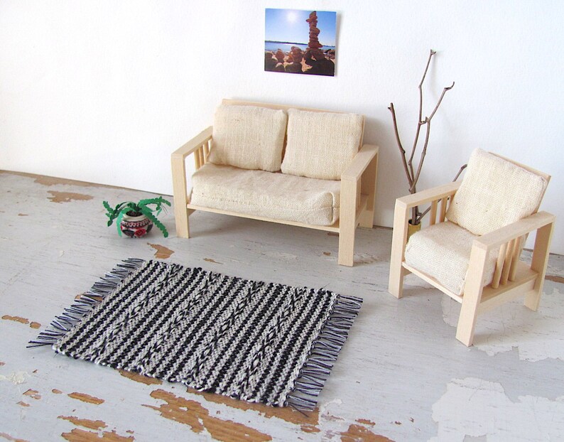 Handmade Inch to Foot Dollhouse Miniature Rug or Carpet,  1:12 Scale Artisan Hand Woven Black and Off-White Stripe and Diamond Pattern Scandinavian Modern, Rustic Farmhouse, Beach Cottage, or Southwest Desert Ranch Collector Dolls House Furniture Accessory Textile. Styled with a couch and chair, a floor vase with sticks, a potted cactus, and a rock photo on the wall.