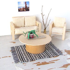 Handmade Inch to Foot Dollhouse Miniature Rug or Carpet,  1:12 Scale Artisan Hand Woven Black and Off-White Stripe and Diamond Pattern Scandinavian Modern, Rustic Farmhouse, Beach Cottage, or Southwest Desert Ranch Collector Dolls House Furniture Accessory Textile. Styled with a couch and chair, a floor vase with sticks, a potted cactus on a round coffee table, and a rock photo on the wall.