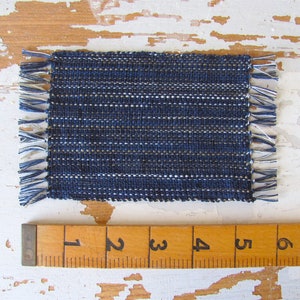 Handcrafted, Inch to Foot Dollhouse Miniature Rug is 1:12 Scale Artisan Hand Loom Woven in Indigo Navy Ocean Blue, Beige, and White Stripe Floor Carpet for Modern Coastal Seaside Nautical Beach House, Cabin Decor Doll House Furniture Accessory. Shown with ruler for scale.