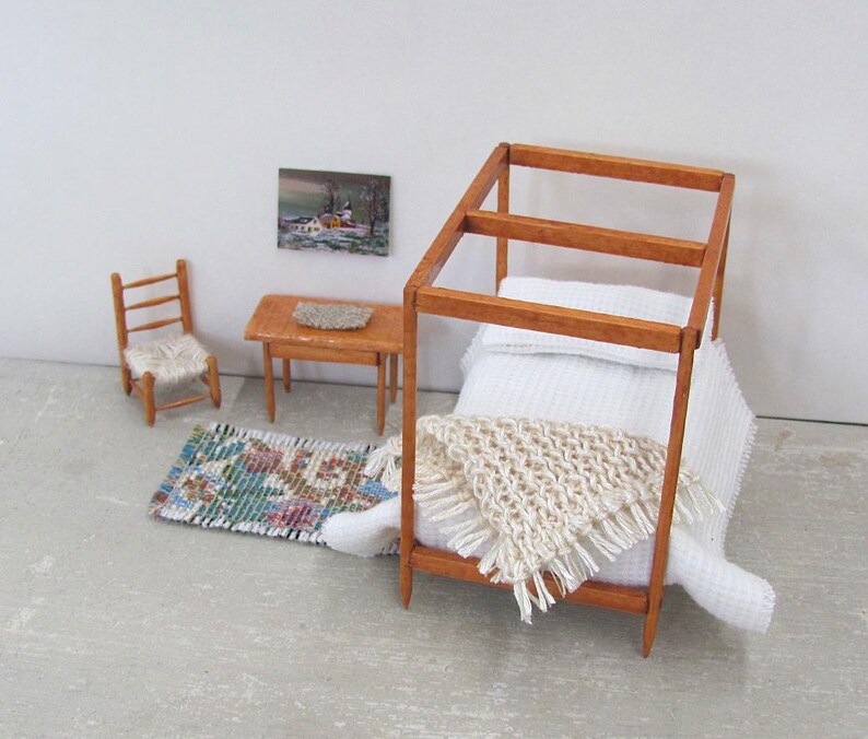 Little Handmade Half Inch to Foot Dollhouse Bed Throw Blanket, 1:24 Scale Miniature Artisan Hand Knit Ivory Cream White Bedspread, Doll House Furniture Bedroom Bedding, Collector Model Home Decor Accent Textile for Traditional Style or Modern Country Farmhouse, Cabin, or Cottage. Styled folded in a triangle on the end of a four post bed with white bedspread, with a brocade rug, chair, table with linen mat, and winter landscape painting on the wall.