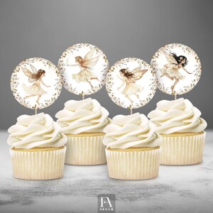 Puede incluir: Cuatro cupcakes con glaseado blanco cubiertos con adornos redondos de cupcakes con temática de hadas. Los adornos presentan ilustraciones de acuarela de hadas con alas y detalles florales.