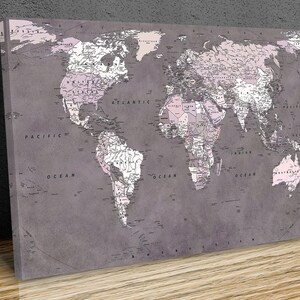 May include: A vintage-style world map print with a grey background and pink accents. The map features detailed outlines of countries and continents, with text labels for oceans and major bodies of water.