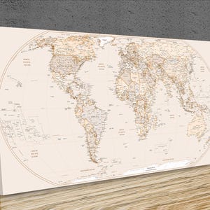 May include: A rectangular canvas wall art piece featuring a detailed world map in shades of beige and light brown. The map displays continents, countries, and oceans with clear text labels for major geographical regions and bodies of water.
