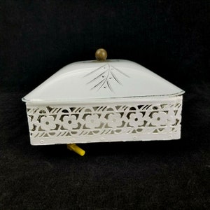 May include: White ceramic covered dish with a floral design on the side. The lid has a wooden knob and a floral design on the top. The dish is on a black background.