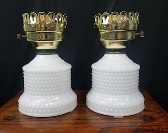 May include: Pair of white milk glass lamp bases with gold metal lampshades. The bases have a textured, beaded design.