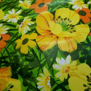 Pode incluir: Um fundo verde com um padr&atilde;o floral com flores amarelas, laranja e brancas. As flores s&atilde;o estilizadas e t&ecirc;m um aspeto retro.