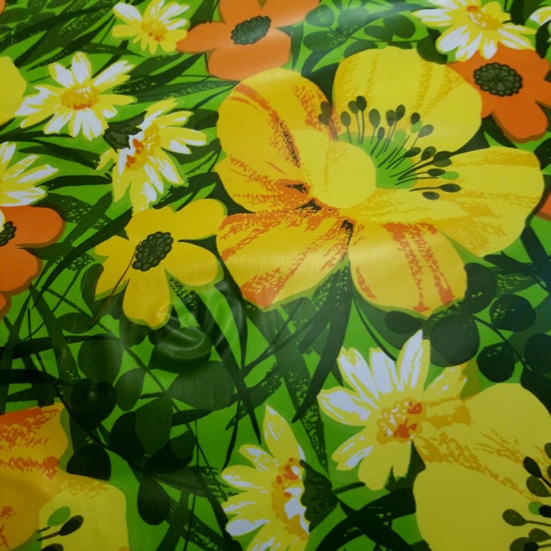 Pode incluir: Um fundo verde com um padr&atilde;o floral com flores amarelas, laranja e brancas. As flores s&atilde;o estilizadas e t&ecirc;m um aspeto retro.