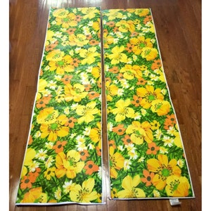 Pode incluir: Dois pain&eacute;is de tecido com padr&atilde;o floral amarelo e laranja. Os pain&eacute;is t&ecirc;m um fundo verde com uma borda branca.