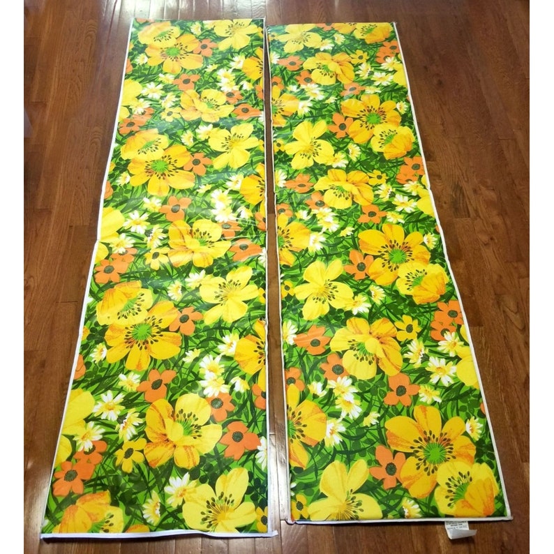 Pode incluir: Dois pain&eacute;is de tecido com padr&atilde;o floral amarelo e laranja. Os pain&eacute;is t&ecirc;m um fundo verde com uma borda branca.