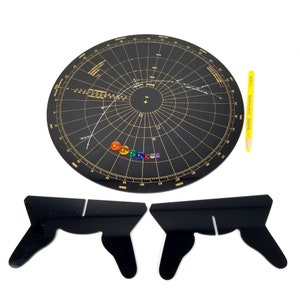 May include: A black circular chart with gold markings and a white line representing a comet's trajectory. The chart is surrounded by a ring of colored gemstones. Two black acrylic stands are also included.