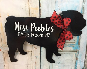May include: Black wooden silhouette of a dog with a red bow with white paw prints. The dog silhouette has the text "Miss Peebles FACS Room 117" written on it.